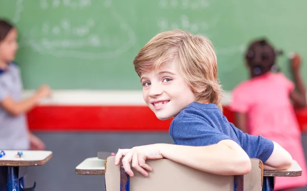 Schoolboy at school in multi race classroom — Stock Photo, Image