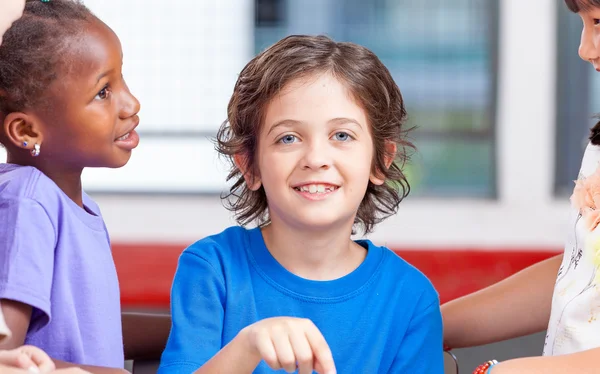 Group of multi ethnic elementary students working with tablet at — Stock Photo, Image