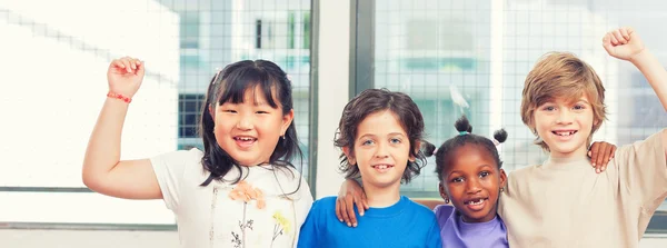 Felices compañeros de clase multiétnicos abrazándose en la escuela primaria —  Fotos de Stock