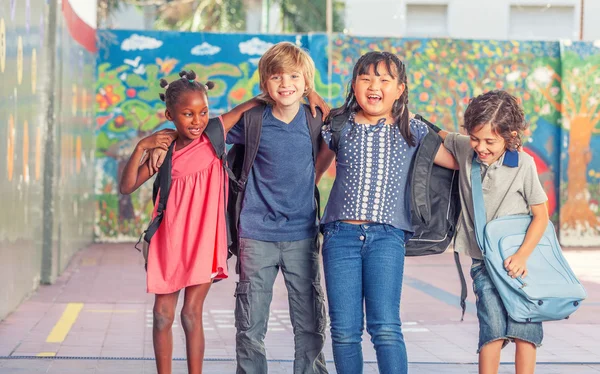 Glückliche multiethnische Klassenkameraden, die sich auf dem Schulhof umarmen, Glück — Stockfoto