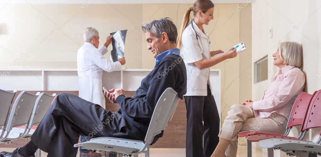 Patients and doctors speaking inside hospital waiting room