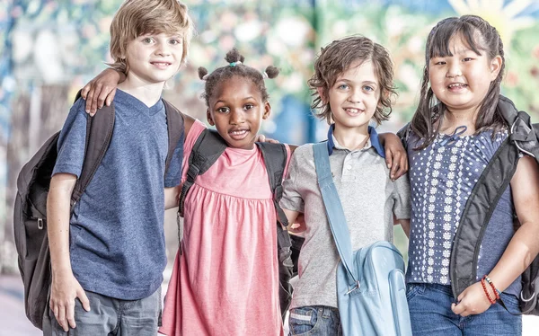 Glückliche multiethnische Klassenkameraden, die sich auf dem Schulhof umarmen, Glück — Stockfoto