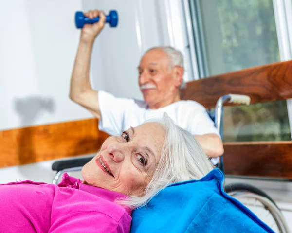 Pareja mayor en la clínica de rehabilitación. Ejercicios y sonrisas —  Fotos de Stock