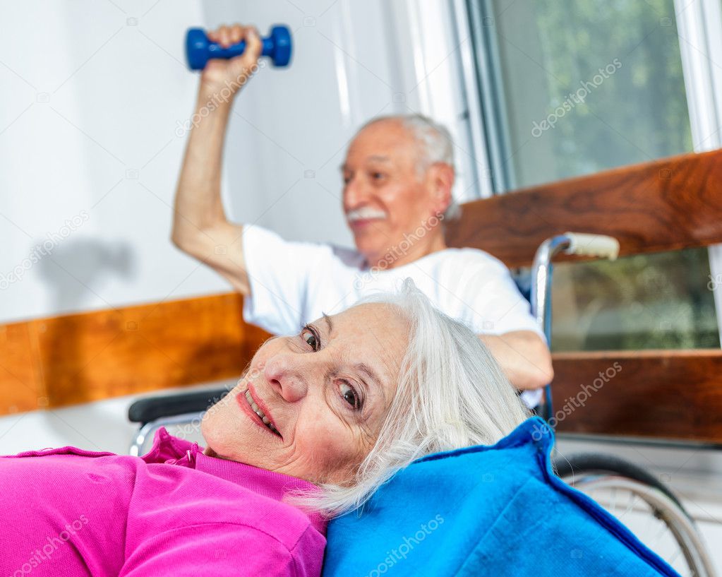 Elder couple in rehab clinic. Exercises and smiles