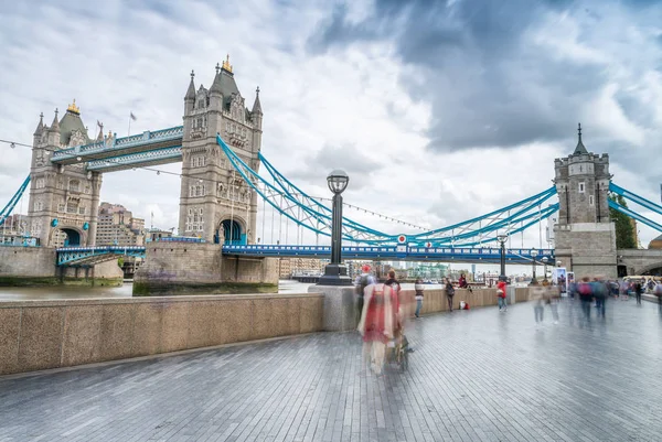 Turisty podél mostu Tower Bridge v Londýně. Vie rozmazané dlouhé expozice — Stock fotografie