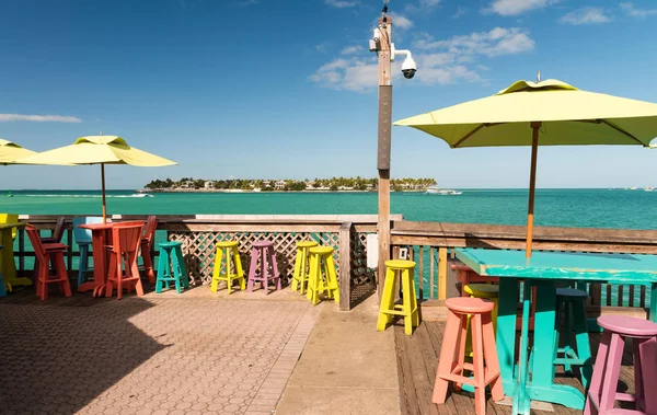 Tables et chaises colorées sur une terrasse au bord de l'océan, holida — Photo