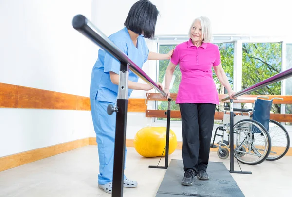 Rehabilitation clinic with elderly people and nurse — Stock Photo, Image