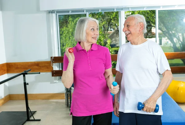 Elderly couple lifting weights at gym — Stock Photo, Image