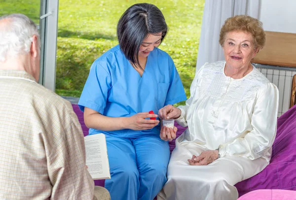 Enfermera asiática dando pastillas a pacientes ancianos en el hospital —  Fotos de Stock