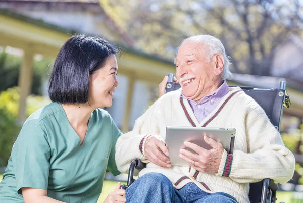 Boldog elder beteg rehabilitációs klinikán kertben tabletta és a smil használatával — Stock Fotó