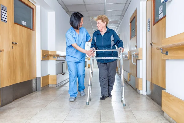 Senior femmina paziente essere assistito da femmina asiatico infermiera in noi — Foto Stock