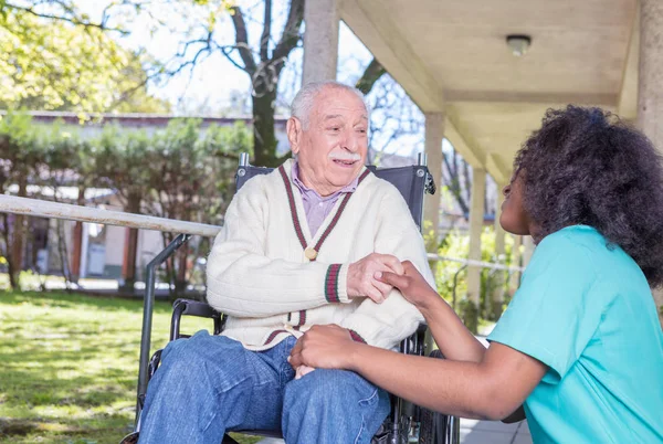 Infirmière aidant patient âgé dans le jardin de l'hôpital — Photo