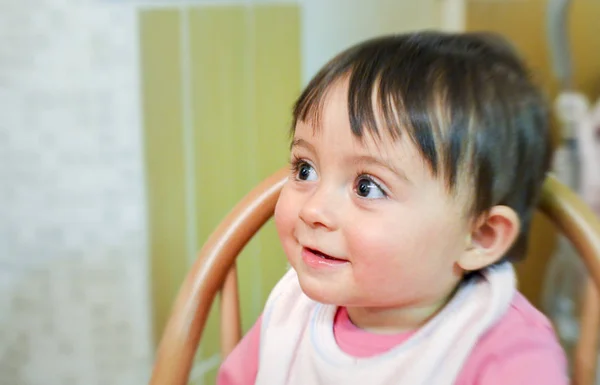 Happy baby girl seated looking on her right — Stock Photo, Image