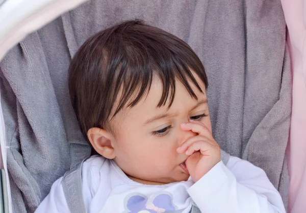 ベビーカーに彼女の指を吸う女の赤ちゃん — ストック写真