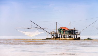 Kayaların üzerinden denizin ortasında ahşap ev