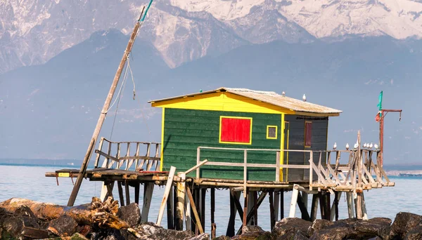 Trähus mitt i havet över stenar — Stockfoto