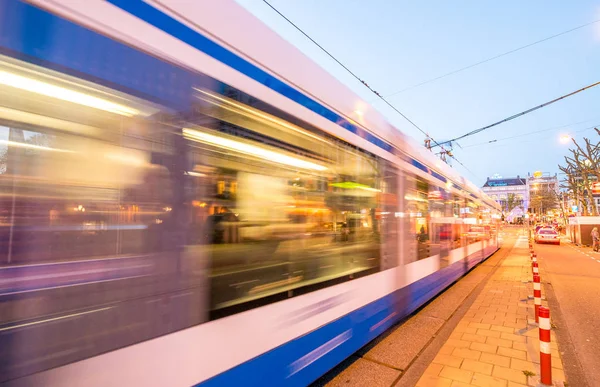 Amsterdam. tram versnellen bij zonsondergang in de straten van stad — Stockfoto