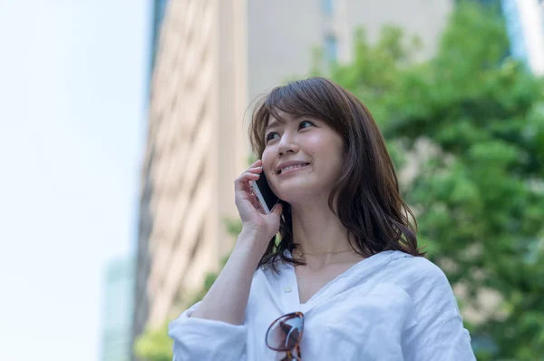 Schöne asiatische Mädchen spricht am Telefon im Freien. Geschäftskonzept — Stockfoto