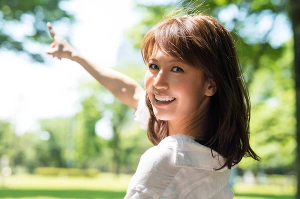 Asian girl relaxing outdoor in Tokyo with finger pointing outwar — Stock Photo, Image