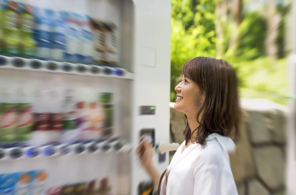 选择在自动售货机 outd 饮料的亚洲美女 — 图库照片