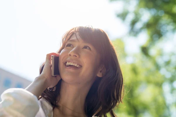 Beautiful asian girl speaking at phone outdoor. Business concept — Stock Photo, Image