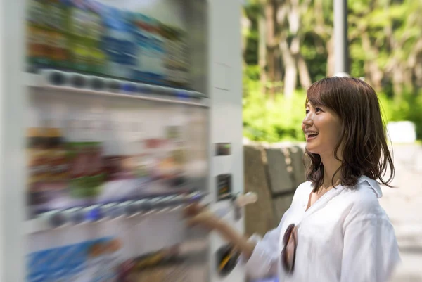 Piękna kobieta azjatyckich wybierając napój o automat bas — Zdjęcie stockowe