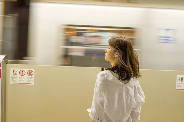 Mulher asiática aguarda trem de metrô na estação — Fotografia de Stock