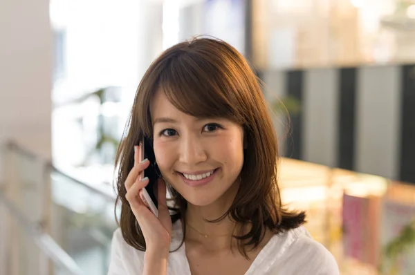 Azjatyckie kobiety odkryty, przemawiając na telefon komórkowy — Zdjęcie stockowe