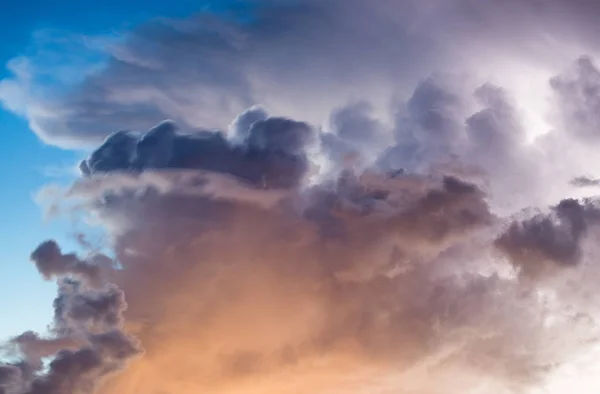 Onweer wolken tegen blauwe hemel bij zonsondergang — Stockfoto