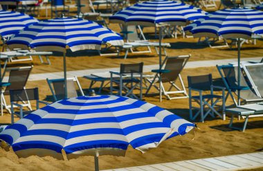 Beyaz ve mavi plaj şemsiyeleri satırları