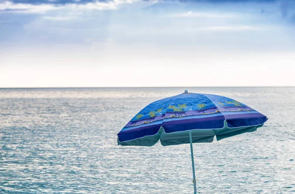 Parapluie de plage bloqué dans l'eau — Photo