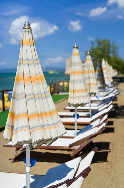 Beach chairs and umbrellas in summer season — Stock Photo, Image
