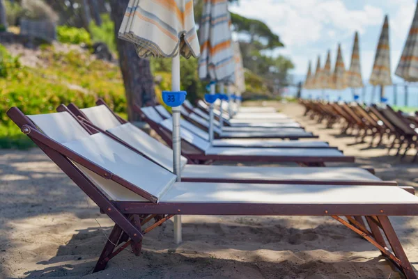 Cadeiras de praia e guarda-chuvas na temporada de verão — Fotografia de Stock