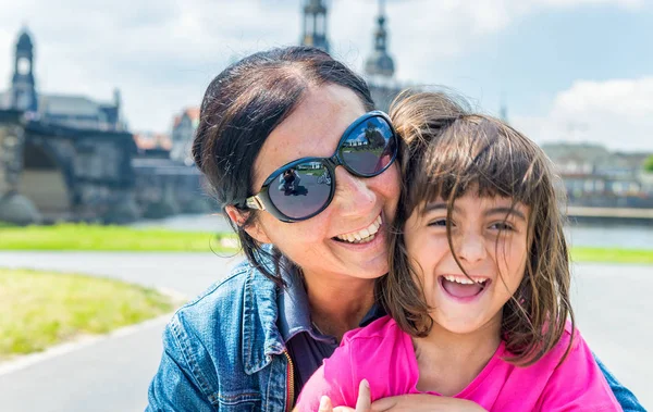 Madre e hija sonriendo mientras visitan la antigua ciudad europea — Foto de Stock