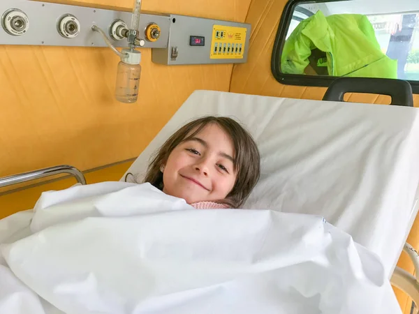 Bambina felice nel letto dell'ambulanza — Foto Stock