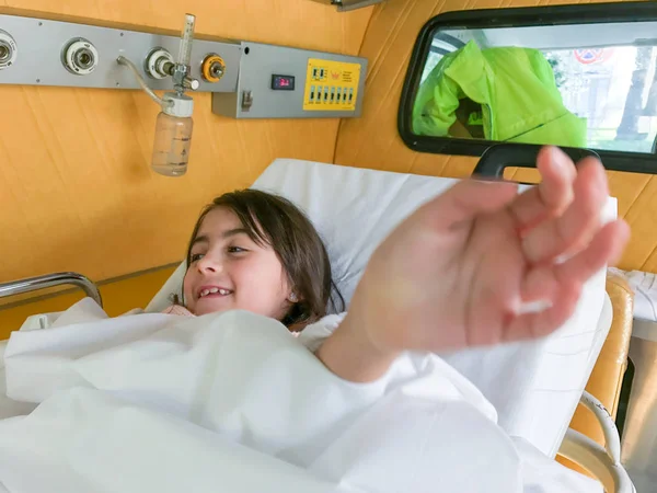 Bambina felice nel letto dell'ambulanza — Foto Stock