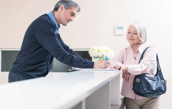 Hospital reception with patients and doctors — Stock Photo, Image