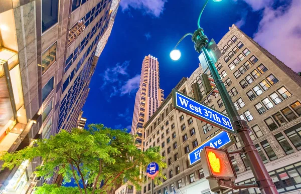 Manhattan in der Nacht. Straßenschilder mit hohen Wolkenkratzern im Hintergrund — Stockfoto