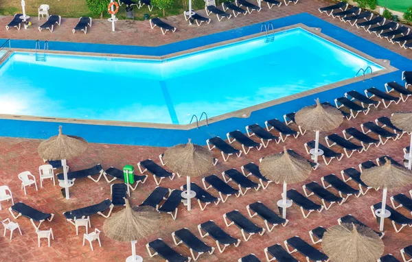 Solstolar längs en vacker pool på natten — Stockfoto