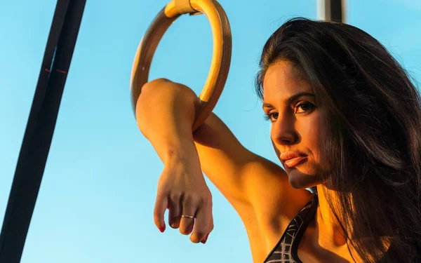 Mooie brunette meisje uitoefenend met ringen op sportschool — Stockfoto