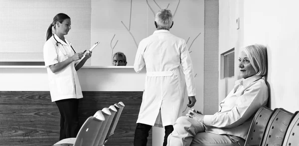 Médicos e pacientes discutindo na sala de espera do hospital — Fotografia de Stock