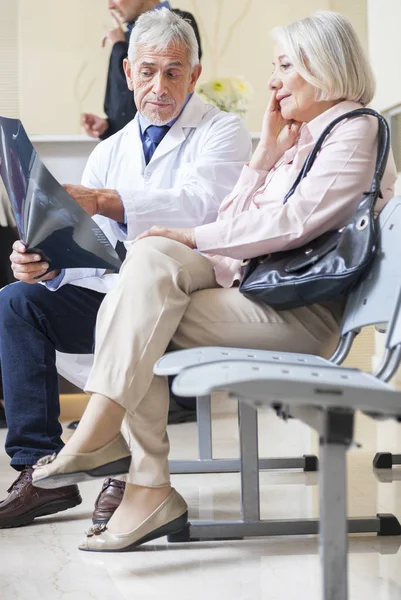 Médecins et patients discutant en salle d'attente de l'hôpital — Photo
