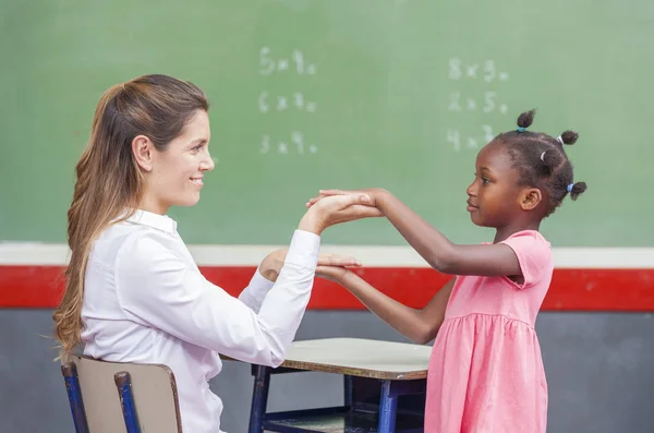 Учительница с африканским ребенком за доской. Школа — стоковое фото