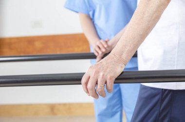 Rehabilitasyon spor salonu detayını. Barda yaşlı insanlar