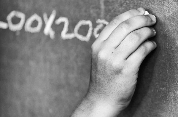 Caucásico niño escritura a mano en pizarra —  Fotos de Stock