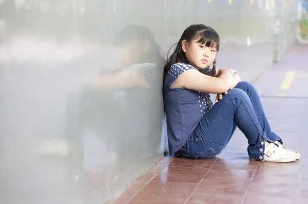 Estudante asiática sozinha em um canto da escola. Conceito de bullying — Fotografia de Stock