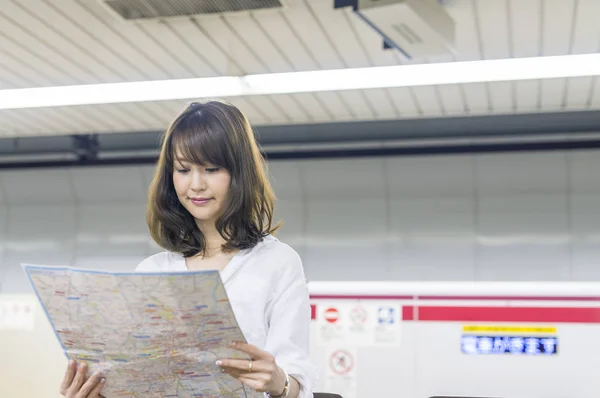 Happy asian business woman indoor looking at city map