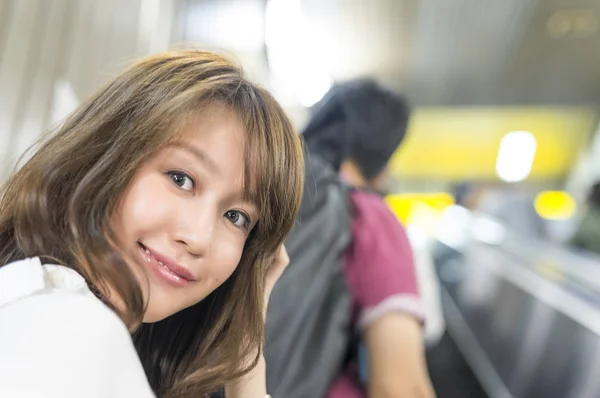 Feliz asiático chica en metro escaleras mecánicas —  Fotos de Stock