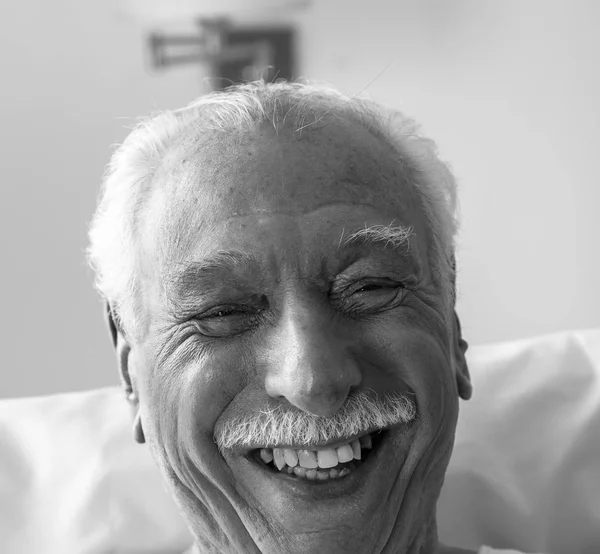 Happy elderly patient smiling in hospital bed. Health and happin — Stock Photo, Image