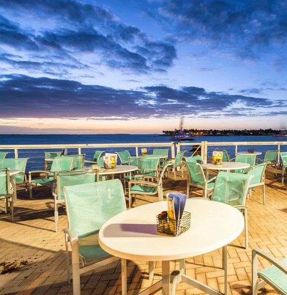 Restaurant with tables over the ocean at sunset. Holiday and rel — Stock Photo, Image